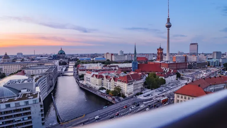 Panoramablick über Berlin mit dem Fernsehturm in der Abenddämmerung bei blauem Himmel.