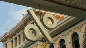 Ein großes Prozentzeichen hängt an einem historischen Gebäude, symbolisiert Zinsentscheidungen der EZB.