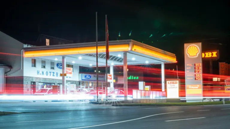 Eine nächtliche Tankstelle in Deutschland mit beleuchteter Preistafel für Benzin und Diesel.