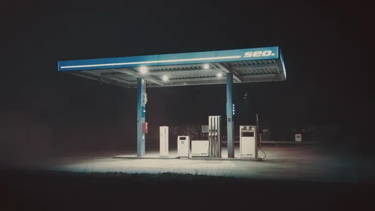 Eine nächtliche Tankstelle unter beleuchtetem Dach für einen Kraftstoffpreis-Artikel.