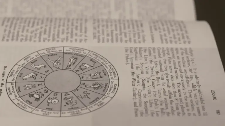 Ein offenes Buch zeigt detaillierte Illustrationen zu den verschiedenen Tierkreiszeichen der Astrologie.