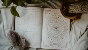 Ein offenes Tagebuch mit astrologischen Illustrationen und Kristallen für spirituelle Reflexion.