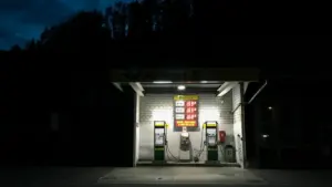 Eine nächtliche Tankstelle mit deutlich sichtbaren Kraftstoffpreisen auf der Preistafel.