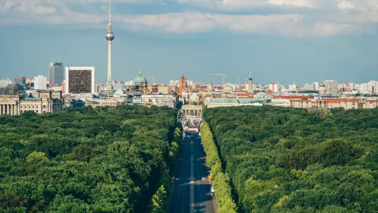 Luftaufnahme von Berlin mit Fernsehturm unter einem strahlend blauen Sommerhimmel.