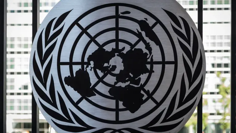 Das UN-Emblem vor einem Fenster am Hauptsitz der Vereinten Nationen in New York.