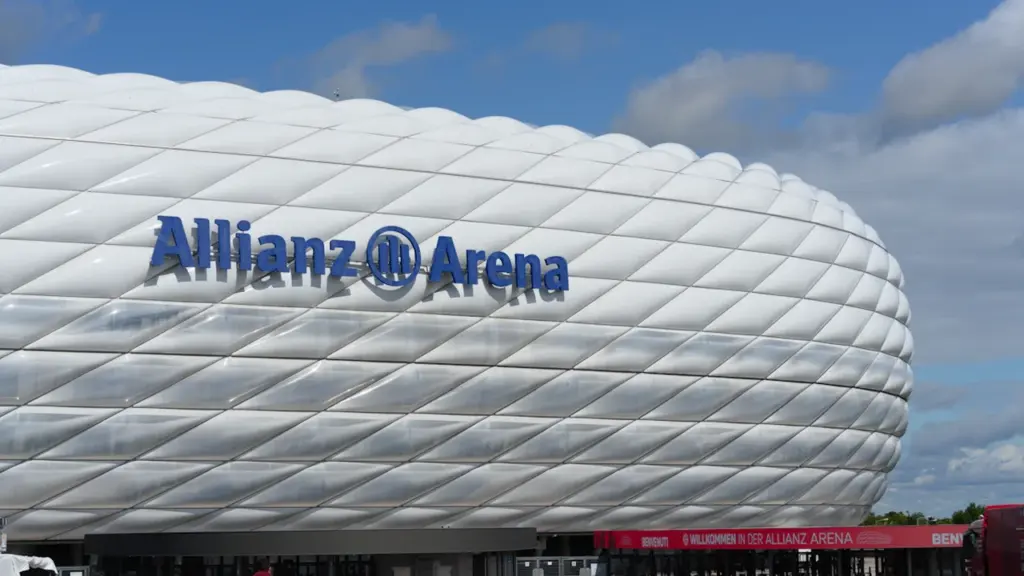Die Allianz Arena in München unter einem strahlend blauen Himmel bei Tageslicht.