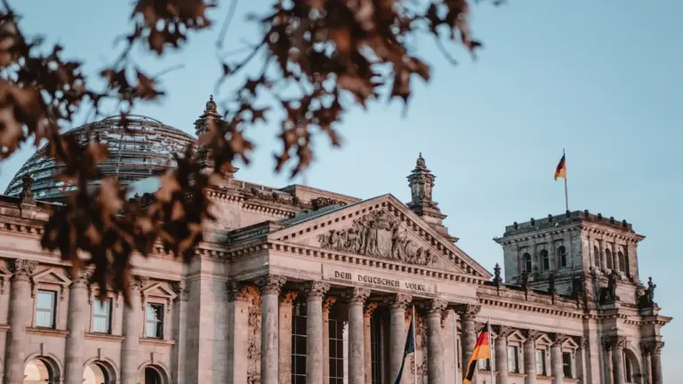 Das Reichstagsgebäude in Berlin bei Tageslicht unter einem klaren blauen Himmel.