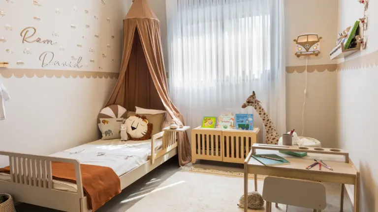 Ein gemütliches Kinderzimmer mit Bett, Schreibtisch und einladender Dekoration in warmen Farben.