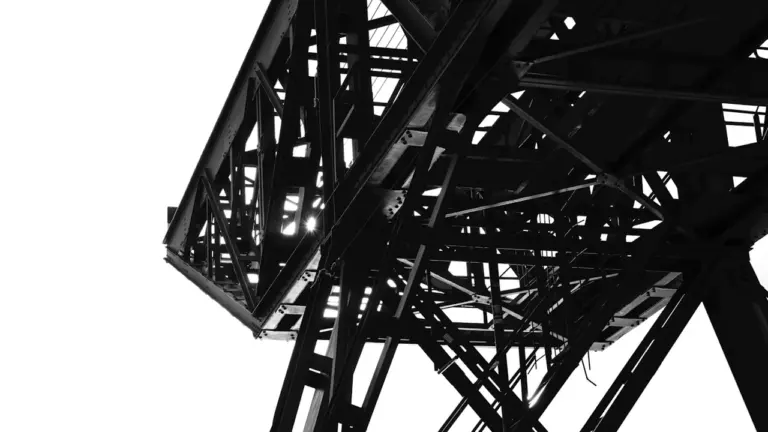 Nahaufnahme einer historischen Metallbrückenkonstruktion in kontrastreichem Schwarz-Weiß.