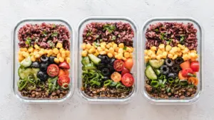 Drei Glasbehälter gefüllt mit gesundem Meal Prep für die gesamte Woche.