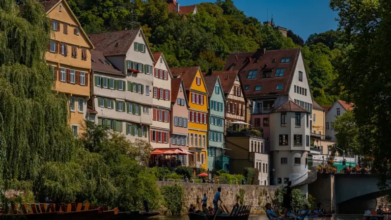 Traditionelle Stocherkähne fahren auf dem Neckar vor der historischen Kulisse der Tübinger Altstadt.