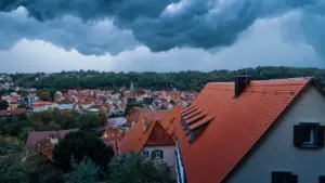 Dramatische dunkle Gewitterwolken über den Dächern einer deutschen Kleinstadt bei Tag.