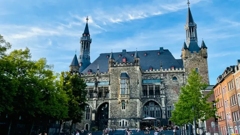 Historisches Rathaus in Aachen vor blauem Himmel an einem sonnigen Tag.