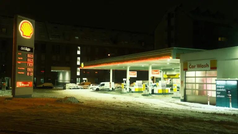 Eine nächtliche Tankstelle mit Preisanzeige, die ideal für Preisvergleiche geeignet ist.