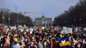 Die deutsche Flagge weht stolz vor einem historischen Gebäude unter bewölktem Himmel.